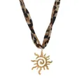 Detailaufnahme des goldenen Sonnenanhängers mit Leopardenmuster-Stoffband für die Kette - Sonnenanhänger / Gold