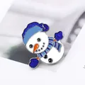 Detalle de un broche de muñeco de nieve navideño con gorro azul de purpurina y esmalte - Estilo Muñeco de Nieve (MZ009)