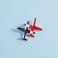 Detail of red and blue enamel airplane brooch with silver metal trim on blue background - Double Overlapping Planes / Red Blue Plane (C1450-2)