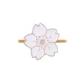 Macro shot of gold cherry blossom napkin ring with white enamel petals and pink accents - White Style (Z1005-2)