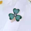 Golden four-leaf clover napkin ring with green enamel and crystal on white cloth - Gold Green Enamel Clover (Z1045)