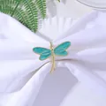 Detailed view of a golden dragonfly napkin ring with teal enamel wings on white fabric - Teal (Z1059-6)