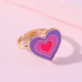 Détail d'une bague dorée réglable avec trois cœurs en émail violet rose et rouge - Cœur Rose Violet (E1209-1)