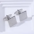 Gros plan détaillé de boutons de manchette carrés argentés avec texture métallique quadrillée - Argent