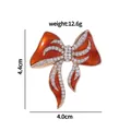 Elegante spilla a fiocco dorata con smalto arancione e strass di cristallo lucenti - Fiocco in Smalto con Strass (C2120)
