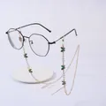Golden eyewear chain with green butterflies and pearls on white display stand - Butterfly Green
