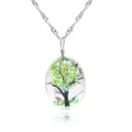 Gros plan du pendentif ovale en verre avec fleurs séchées vertes et motif papillon - Style Arbre Vert (A2557-1)