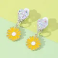 Detail of heart-shaped clip-on earrings with yellow daisy pendants and soft pads - Daisy