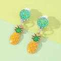 Close-up of cute yellow pineapple clip-on earrings with green glitter disc detail - Pineapple
