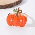 Dettaglio di un portatovaglioli a forma di zucca in smalto arancione con base dorata e foglie - Forma di Zucca
