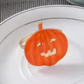 Dettaglio di un portatovagliolo a zucca arancione con sorriso su piatto di porcellana - Zucca Sorridente