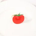 Dettaglio ravvicinato di un portatovagliolo a forma di pomodoro rosso su un piatto di ceramica - Forma di Pomodoro Rosso