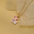 Cute gold necklace with white enamel alpaca pendant featuring a red flower and purple bow - White Flower Alpaca (A2889-24)