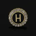 Golden round brooch with black H initial and crystal rhinestones on a black background - C2173-H Brooch