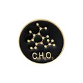 Macro detail of a black enamel science pin featuring gold molecular structure and C8H8O3 - Chemical Molecular Formula Style (C2417-1)