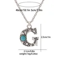 Macro detail of vintage turquoise G-letter pendant with engraved western totem motifs - A3217-G