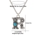 Detail of vintage silver-tone letter R necklace with turquoise and eagle engraving - A3217-R