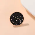 Vue détaillée d'une broche Bélier ronde en émail noir avec des accents dorés élégants - Bélier