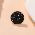 Gros plan d'un badge rond en émail noir avec le motif doré du signe du zodiaque Taureau - Taureau