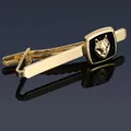 Detail of a gold tie clip with a black wolf head design on a reflective surface - Gold Wolf Tie Clip
