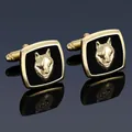 Detail shot of men's gold wolf head cufflinks with black enamel on a reflective surface - Golden Wolf Head Cufflinks