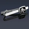 Macro detail of silver tie clip with lion-eagle emblem on polished black enamel base - Silver Griffin Tie Clip
