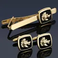 Golden horse head cufflinks and tie clip set with black enamel on blue reflective surface - Gold Griffin Set