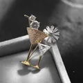 Close-up of golden cocktail glass brooch with sparkling white zircons on grey velvet base - Gold Cocktail Glass (K1015-GO)
