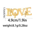 Goldene LOVE-Brosche mit drei Engeln und Amors Relief in glänzender Goldoptik - Goldene LOVE Cupido Form (C2742-2)