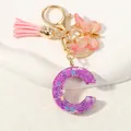 Close-up of purple resin letter C keychain with glitter, pink butterfly and tassel charms - Alphabet C (D1414-C)