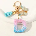 Resin letter D keychain with pink-blue gradient, star sequins, and gold butterfly charm - Letter D (D1417-D)