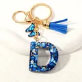 Detail of blue letter D resin keychain with butterfly pendant and suede tassel charm - Letter D (D1413-D)