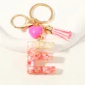Close-up of resin letter E keychain with pink shells, gold foil and a suede tassel - Style E(D1416-E)
