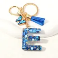 Detailed close-up of blue resin letter E keychain with gold foil and butterfly charm - Letter E (D1413-E)