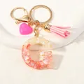 Detailed view of resin letter G keychain with pink shell inlay and heart tassel - Style G(D1416-G)