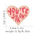 Detail view of heart enamel pin with You Are Strong text including size and weight specs - You Are Strong Quote / Pink Heart Style (C3048-1)