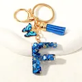 Letter F keychain with blue butterfly, leather tassel and gold flakes resin detail - Letter F (D1413-F)
