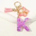Portachiavi lettera K viola glitterata con fiocco di neve, nappa in pelle e farfalla - Alfabeto K (D1414-K)