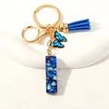 Blue tassel and butterfly resin letter keychain with gold lobster clasp and seashell texture - Letter I (D1413-I)