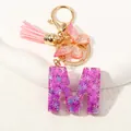 Portachiavi lettera M in resina viola con nappa rosa, paillettes e farfalla dorata - Alfabeto M (D1414-M)