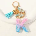 Letter K resin keychain with pink blue glitter, blue tassel and golden butterfly charm - Letter K (D1417-K)