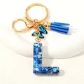 Letter L keychain with blue glitter resin, butterfly charm and dark blue suede tassel - Letter L (D1413-L)