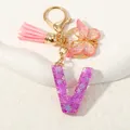 Portachiavi lettera V in resina viola con paillettes, nappa rosa e farfalla dorata - Alfabeto V (D1414-V)