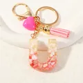 Pink resin letter U keychain with gold foil, shell chips, and a matching tassel charm - Style U(D1416-U)