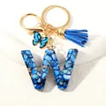 Letter W keychain with blue resin shell flakes, gold foil, butterfly, and tassel - Letter W (D1413-W)