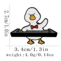 Cartoon enamel duck pin playing piano keyboard with red bow, size 3.4cm by 2.7cm - C3178-5