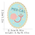 Broche médicale ovale bleue en émail avec stéthoscope rose et détails dorés - Style Médical Oval Bleu Clair (C3333-2)