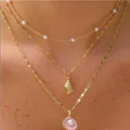 Three-layer gold necklace set featuring white pearls, conch and pink seashell pendants - 6495401hb