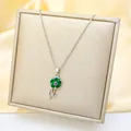 Macro detail of silver flower pendant with green heart petals and pink stone on silk - Silver - Green Sunflower