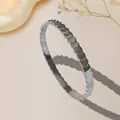 Silver stainless steel bangle with a unique geometric fish scale pattern on warm background - Silver Style (T213)